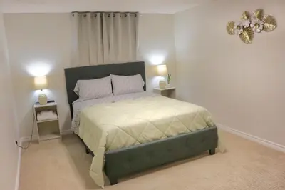 a bedroom with a bed with two night stands and two lamps at Home beside WEM in Edmonton