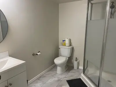 a white bathroom with a toilet and a shower at Home beside WEM in Edmonton
