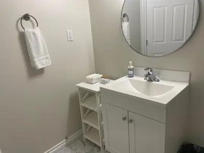 a white bathroom with a sink and a mirror at Home beside WEM in Edmonton