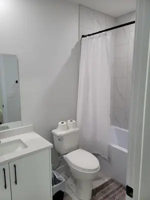 a white bathroom with a toilet and a shower at Cozy Suite near West Edmonton Mall in Edmonton