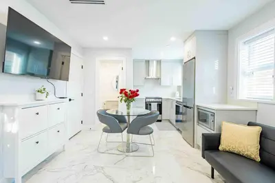 a kitchen with a table and a couch in a room at Charming & Brand-New near Restaurants & Transport in Vancouver