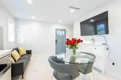 a living room with a glass table and red roses at Charming & Brand-New near Restaurants & Transport in Vancouver