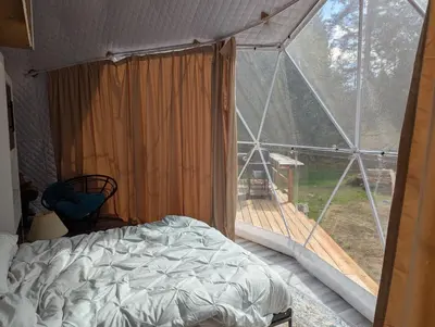a bedroom with a bed and a large window at Bela bahia in Qualicum Beach