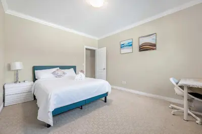 a white bedroom with a bed and a desk at Coquitlam Heights Private Room in Coquitlam