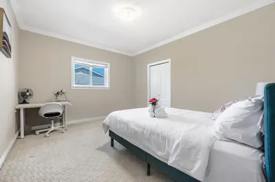 a bedroom with a bed and a desk and a window at Coquitlam Heights Private Room in Coquitlam
