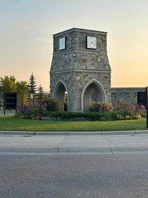 a building with a clock tower in the grass at Peaceful Haven in Prime Location in Calgary