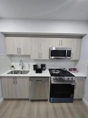 a kitchen with a stove and a sink and a microwave at Peaceful Haven in Prime Location in Calgary