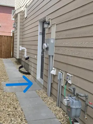 a meter on the side of a house with a blue arrow at Cozy Basement Suite, SW Calgary in Calgary