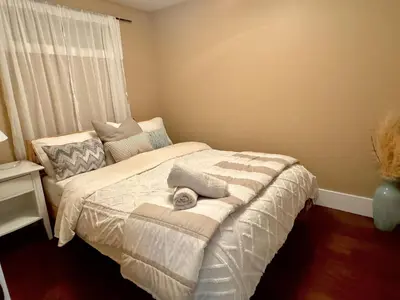 a small bedroom with a bed with a window at Cozy 1 Bedroom Suite in Vancouver