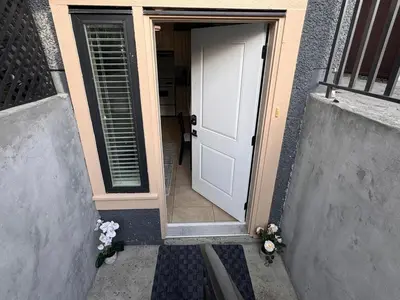 an open door of a house with flowers on the steps at Cozy 1 Bedroom Suite in Vancouver