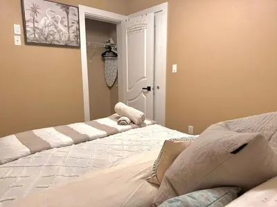 a bedroom with two beds and a door to a room at Cozy 1 Bedroom Suite in Vancouver