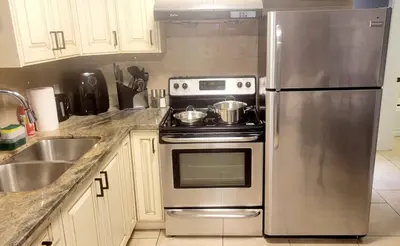 a kitchen with a stove and a stainless steel refrigerator at Quiant 2 Bedroom Suite in Vancouver