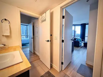a bathroom with a sink and a door to a room at Calgary&Downtown&BMO Centre & Parking in Calgary