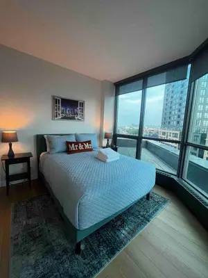 a bedroom with a large bed and a large window at Calgary&Downtown&BMO Centre & Parking in Calgary