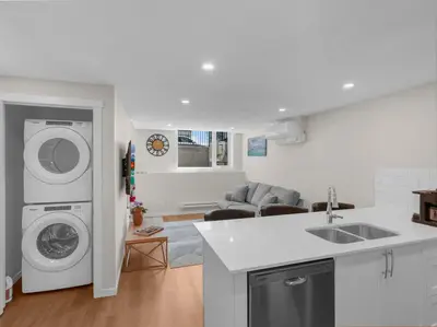 a kitchen and living room with a washer and dryer at Superb 1-Bdr Apt in New Condo in Calgary