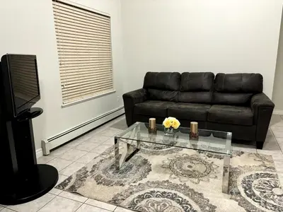 a living room with a black couch and a glass table at 3 Bed - Best View in Town! in Surrey