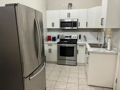a kitchen with white cabinets and a stainless steel refrigerator at 3 Bed - Best View in Town! in Surrey
