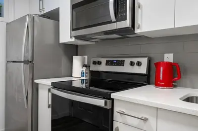 a kitchen with a stove and a microwave at Private Basement Magnolia Retreat Family Friendly Suite near Seton and Lake in Calgary