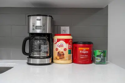 a kitchen counter with a coffee maker and a can of coffee at Private Basement Magnolia Retreat Family Friendly Suite near Seton and Lake in Calgary