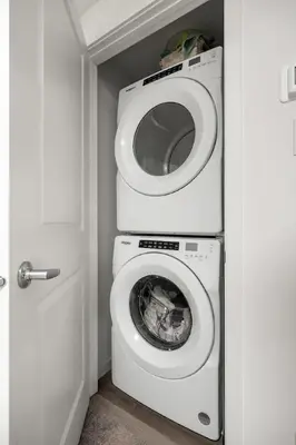 a bathroom with a toilet with a washing machine at Private Basement Magnolia Retreat Family Friendly Suite near Seton and Lake in Calgary