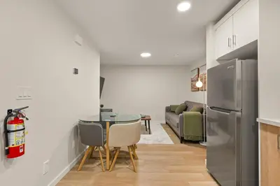 a kitchen and dining room with a table and a refrigerator at Cozy 2BR BSMT Suite with Board Games and Netflix in Calgary