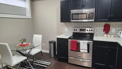 a kitchen with a stove and a table with chairs at Oasis at Heritage in Fort McMurray