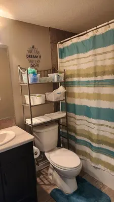 a bathroom with a toilet and a shower curtain at Oasis at Heritage in Fort McMurray