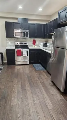 a kitchen with black cabinets and stainless steel appliances at Oasis at Heritage in Fort McMurray
