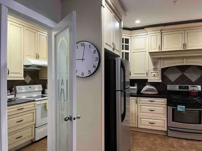 a kitchen with a clock on the wall at Luxury New 5-bedroom 4- bathroom Single House in Surrey