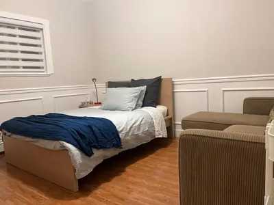 a bedroom with a bed with a pillow and a couch at Luxury New 5-bedroom 4- bathroom Single House in Surrey