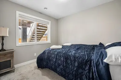 a bedroom with a bed and a window at Cozy & Large Furnished 2-Bedroom Suite in Calgary