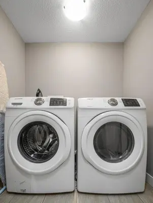 two washing machines sitting next to each other in a room at Cozy & Large Furnished 2-Bedroom Suite in Calgary