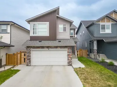 a house with a garage in the driveway at Cozy & Large Furnished 2-Bedroom Suite in Calgary