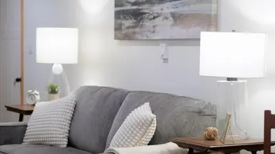a living room with a gray couch and a lamp at Lay Back Lodge in Kimberley