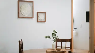 a table with a chair and two pictures on the wall at Lay Back Lodge in Kimberley