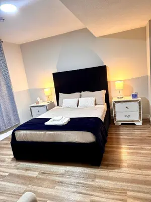 a bedroom with a large bed and two night stands at Homey Basement Suite by Gaudi in Calgary