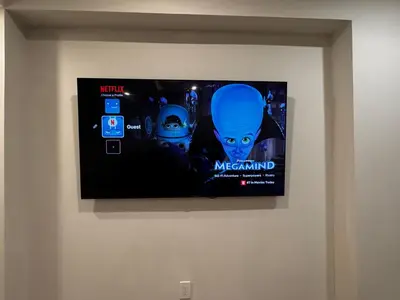 a tv on a wall with a movie on it at Homey Basement Suite by Gaudi in Calgary