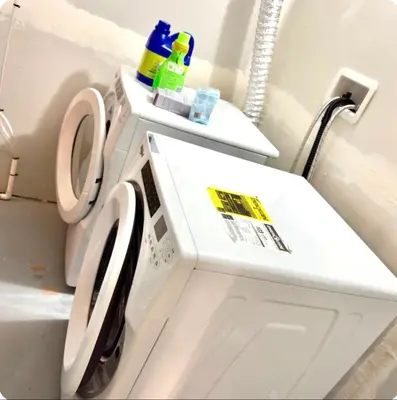 a white washer and dryer in a bathroom at Homey Basement Suite by Gaudi in Calgary