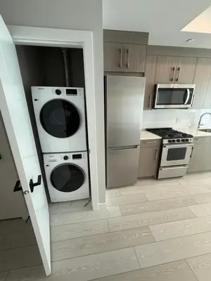 a kitchen with a refrigerator and a washer and dryer at Calgary place in Calgary