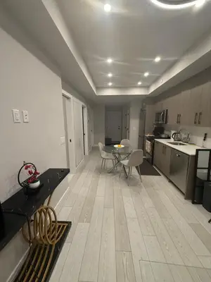 a kitchen and living room with a table and chairs at Calgary place in Calgary