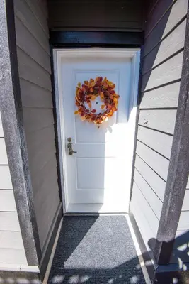 a door leading into a house with a wreath on it at Beach Breeze White Rock in White Rock