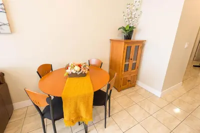 a dining room table with a yellow scarf on it at Beach Breeze White Rock in White Rock