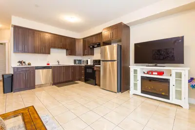 a large kitchen with wooden cabinets and stainless steel appliances at Beach Breeze White Rock in White Rock