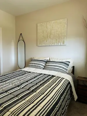 a bedroom with a large bed with a mirror at Oceana Retreat Cozy 1BR with Outdoor Oasis in Victoria