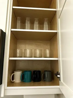 a cupboard with several mugs and plates on it at Oceana Retreat Cozy 1BR with Outdoor Oasis in Victoria