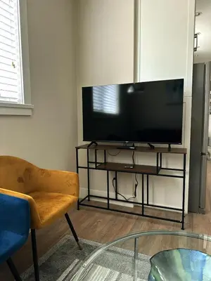 a living room with a flat screen tv on a stand at Oceana Retreat Cozy 1BR with Outdoor Oasis in Victoria