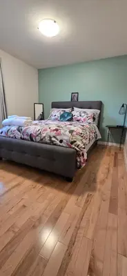 a bedroom with a bed and a wooden floor at Northern Manor in Yellowknife