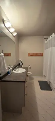 a bathroom with a sink and a toilet and a mirror at Northern Manor in Yellowknife