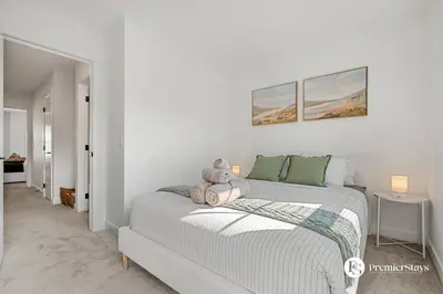 a bedroom with a bed with a teddy bear on it at Modern Luxury Townhome near Aspen Landing and Winsport in Calgary