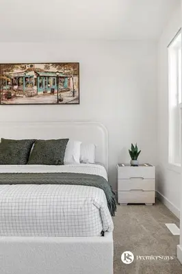 a bedroom with a bed and a painting on the wall at Modern Luxury Townhome near Aspen Landing and Winsport in Calgary